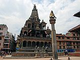 Kathmandu Patan Durbar Square 12 Krishna Mandir And Garuda Column Garuda kneels with folded arms on top of the column facing the Krishna Mandir in Patan�s Durbar Square. Krishna Mandir (1637) is an Indian style stone temple with a shikhara-style spire on top.